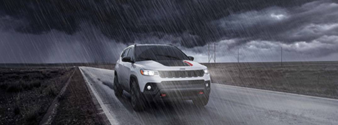 2026 Jeep Compass Sport driving down road as it rains