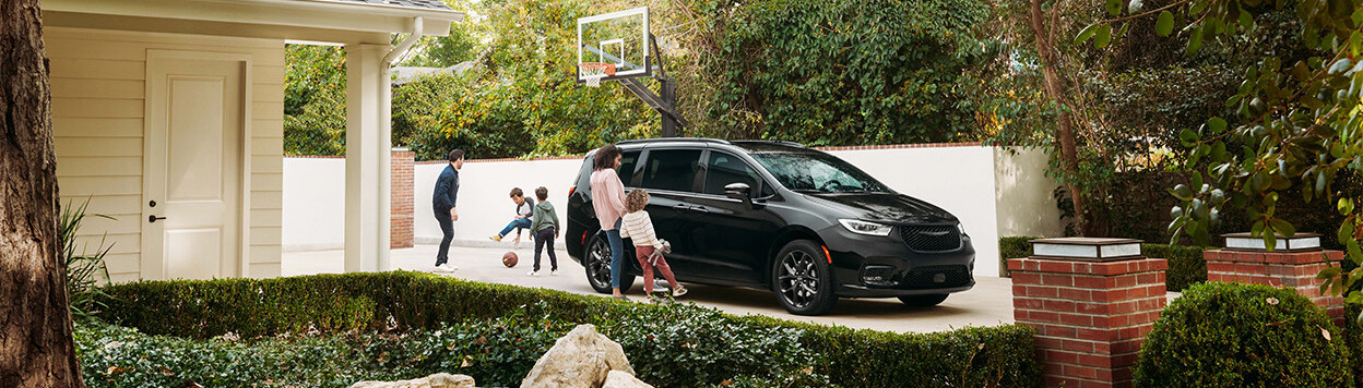 People standing around 2026 Chrysler Pacifica parked on driveway.