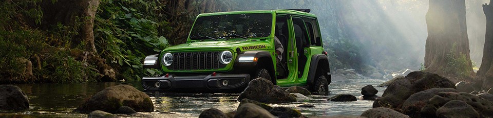 2026 Jeep Wrangler without doors driving through river surrounded by forest
