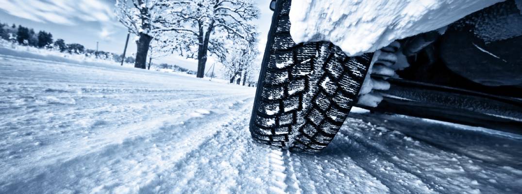 Car driving through snow closeup on tire