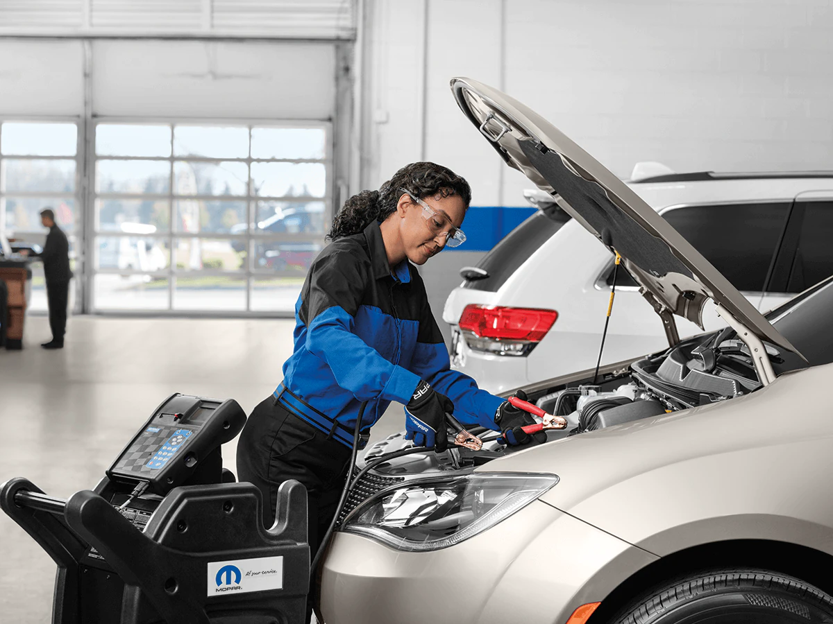 Service tech working under the hood of a vehicle